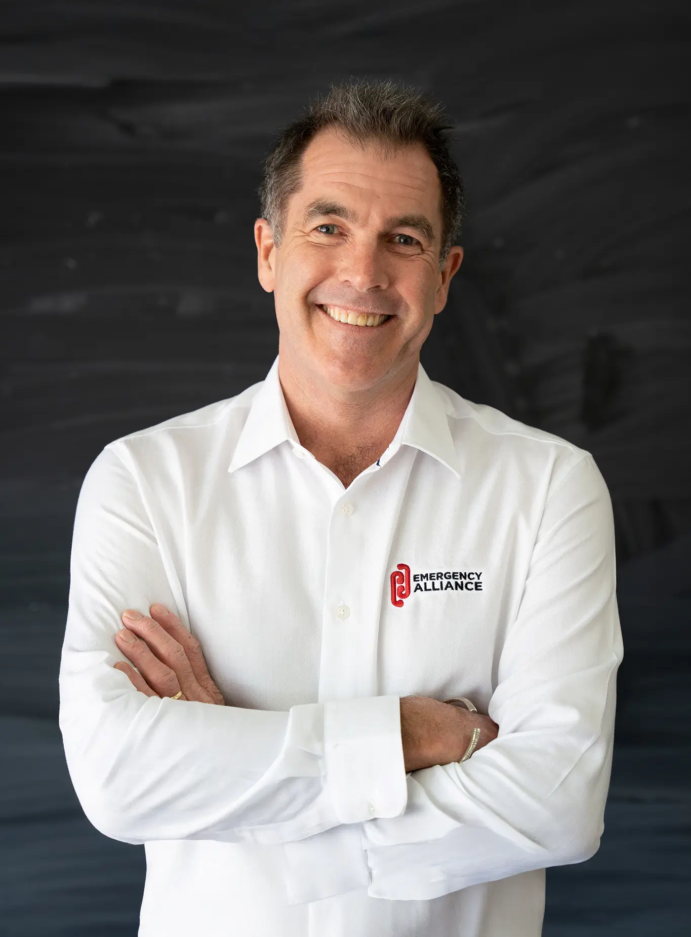 Paul Brown in a white business shirt standing against a black background